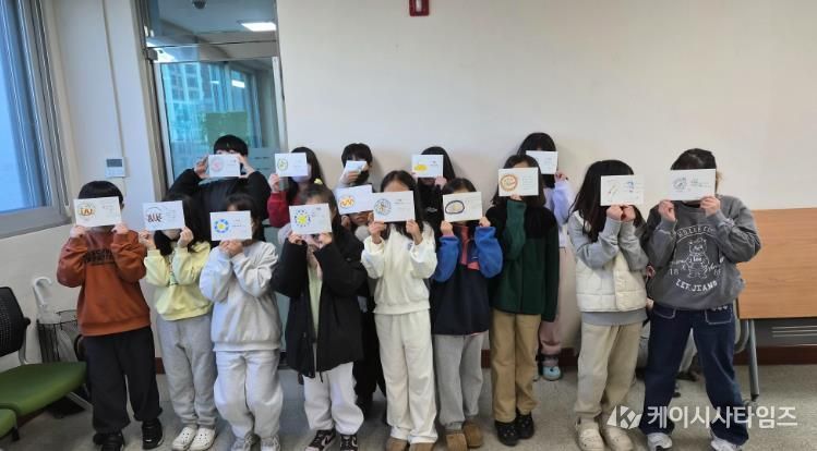 울산 초등학생들이 3일 울주도서관에서 '그림책 담은 멋 글씨 엽서' 활동을 하고 기념사진을 찍고있다