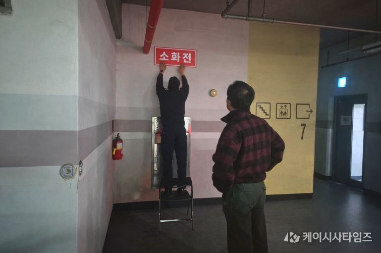 영동소방서 관계자가 아파트 지하주차장에 '보이는 소화전' 표지를 부착하고 있는 모습