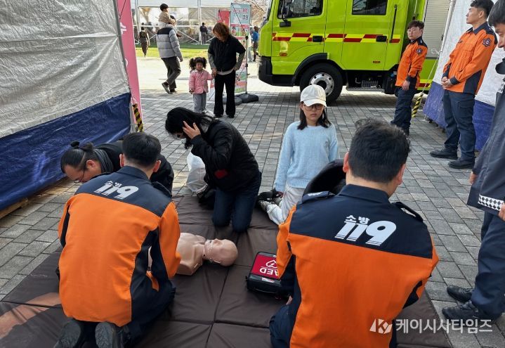 제54회 강진청자축제 119안전체험장에서 어린이와 부모님이 함께 심폐소생술을 배우고 있는 모습.