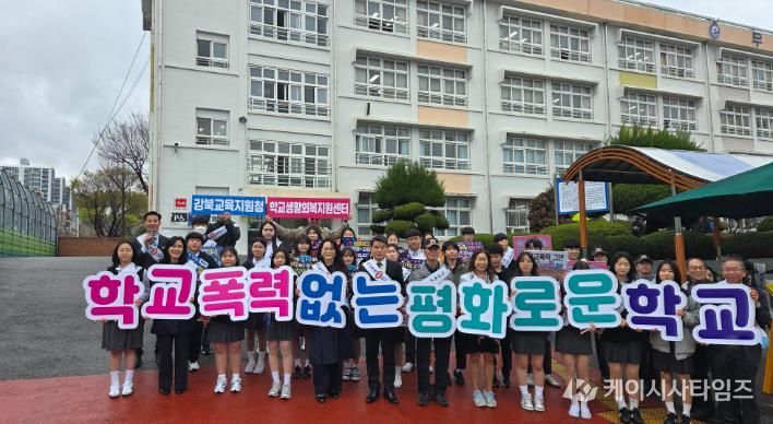 강북교육지원청 한성기 교육장과 학생들이 31일 무룡중학교에서 등굣길 학교폭력 예방 홍보활동을 하고 기념사진을 찍고있다